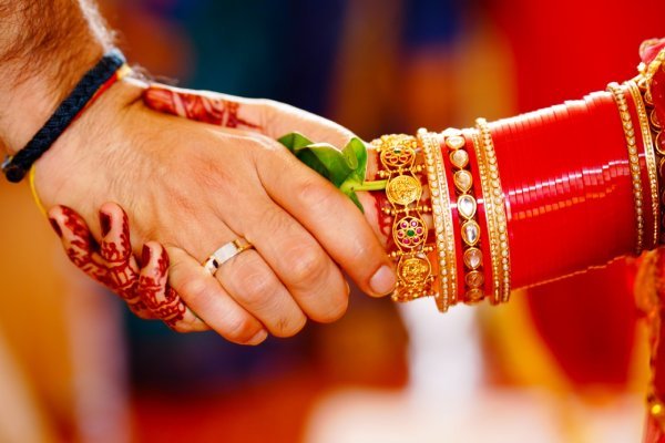 A photograph capturing the handshake between the bride and groom during a traditional Kerala-style wedding ritual, taken by Sidphoto photographer.