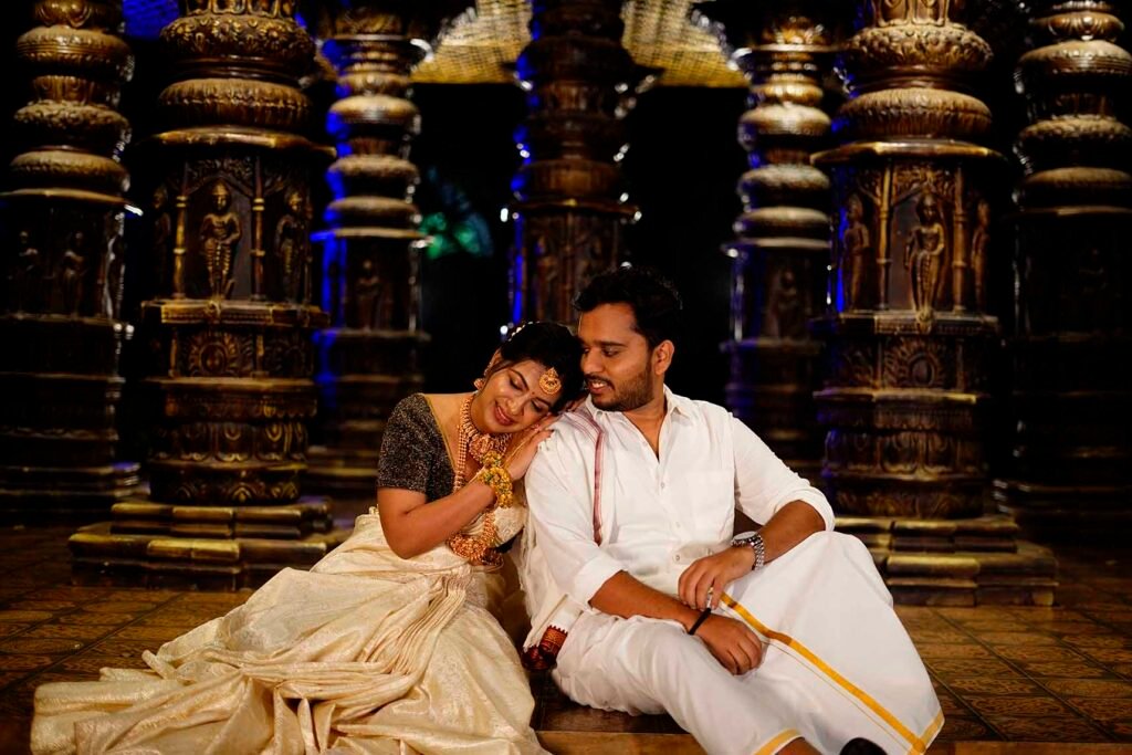 South Indian couple in traditional Kanjeevaram saree and veshti posing near Meenakshi Temple during a cultural pre-wedding photoshoot.